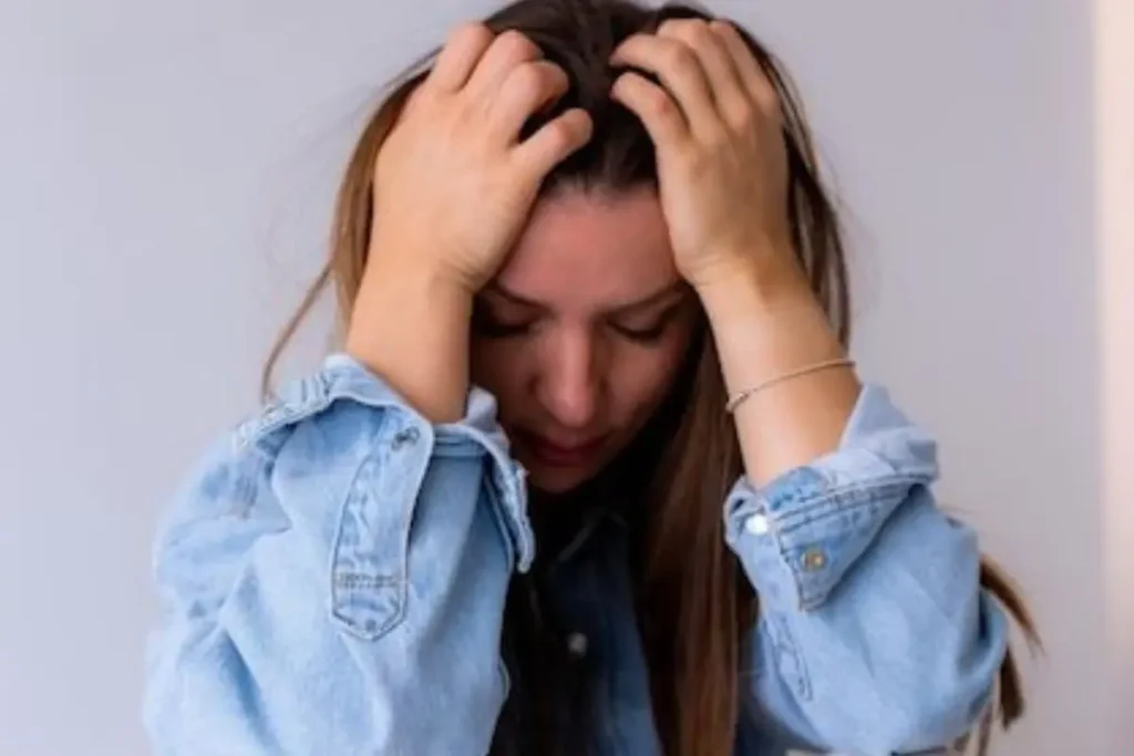 Mulher triste com as mãos na cabeça