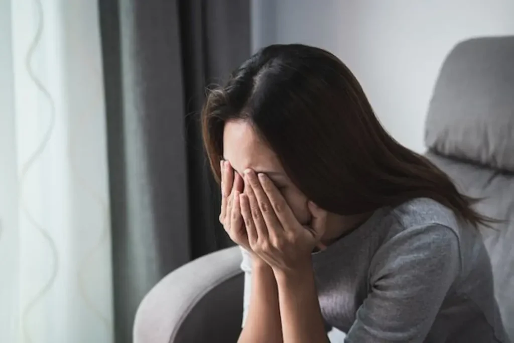 Mulher triste com as mãos no rosto