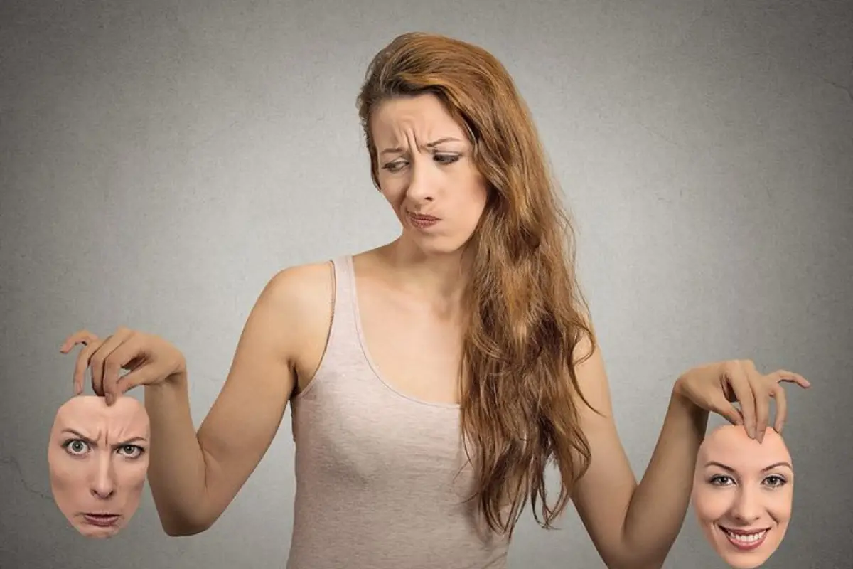 Transtorno Bipolar O Que é, Quais os Sintomas e Como Buscar Tratamento - Mulher segurando 2 máscaras