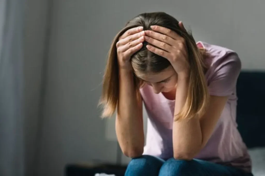 Jovem triste com as mãos na cabeça