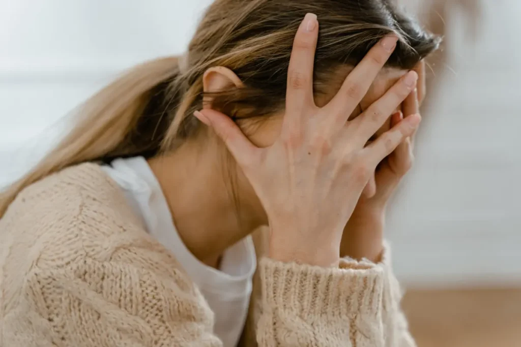 Mulher triste com as mão no rosto