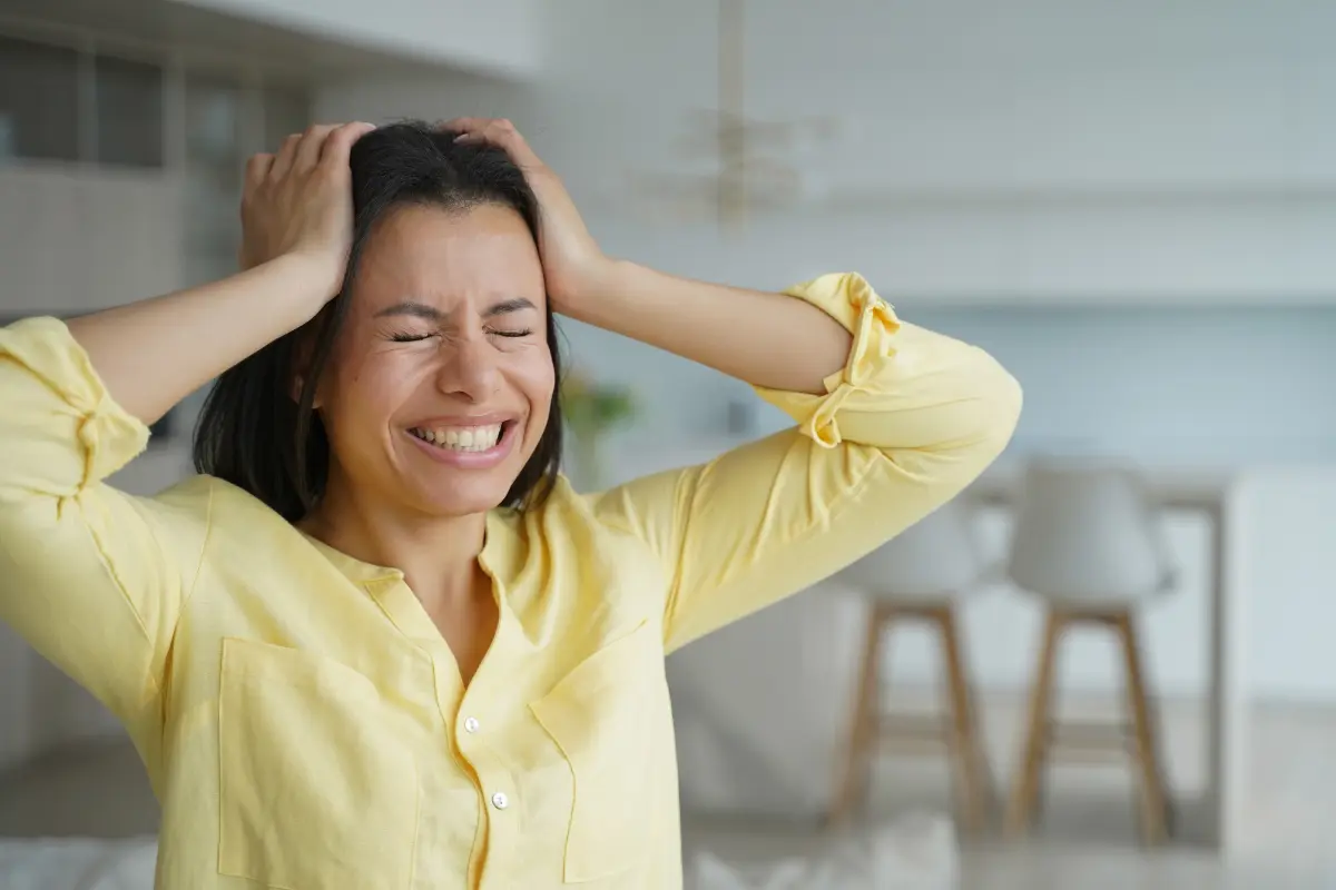 Mulher chorando e com as mãos na cabeça