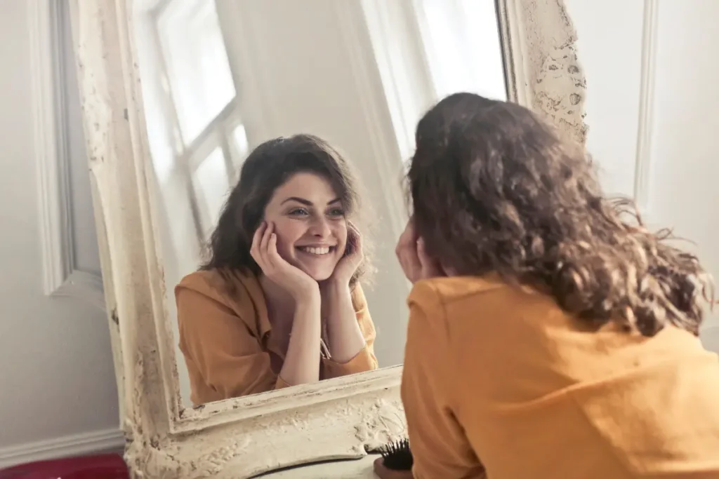 Mulher sorrindo se olhando no espelho