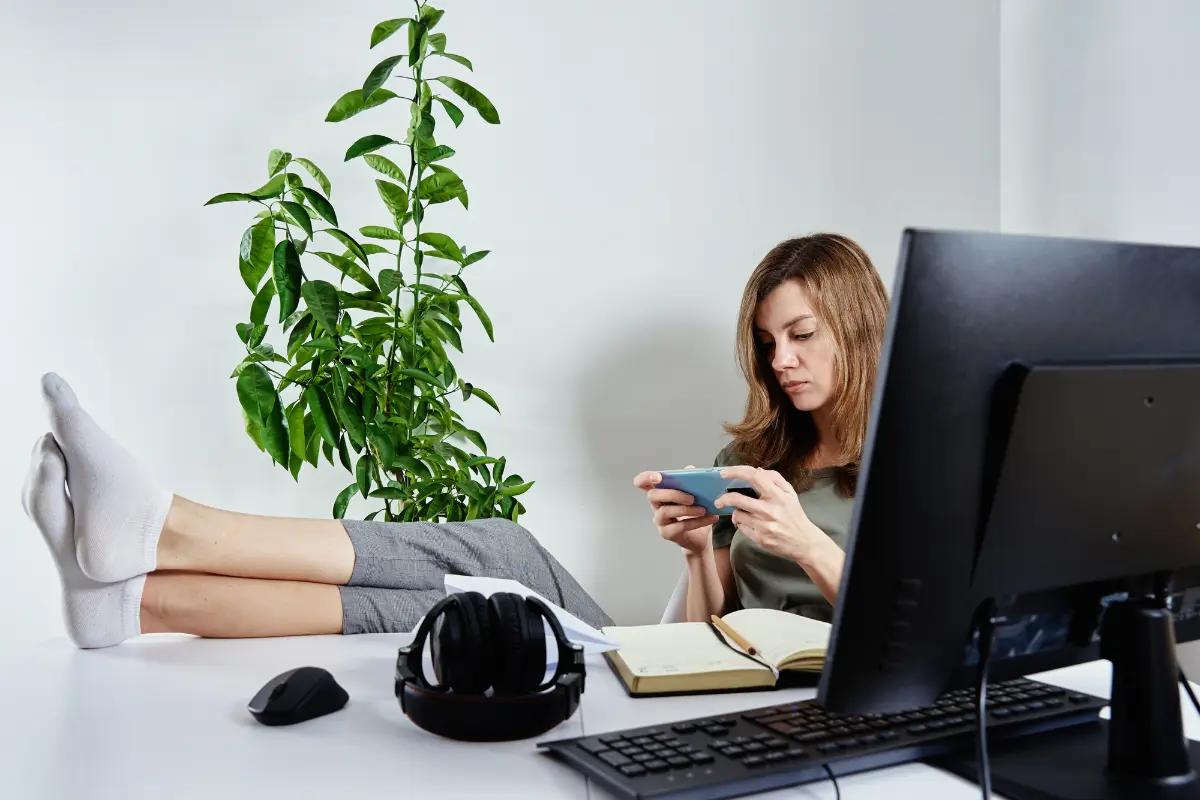 Moça mexendo no celular ao invés de estudar