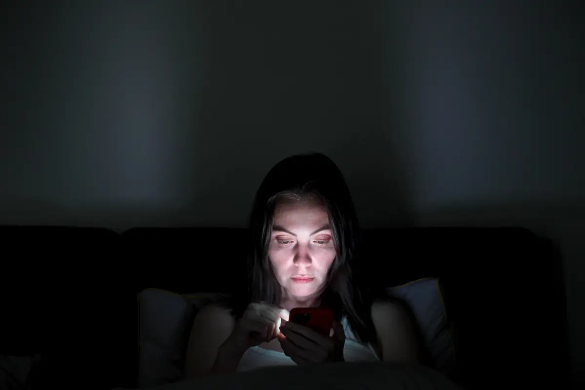 Mulher com insônia usando o celular