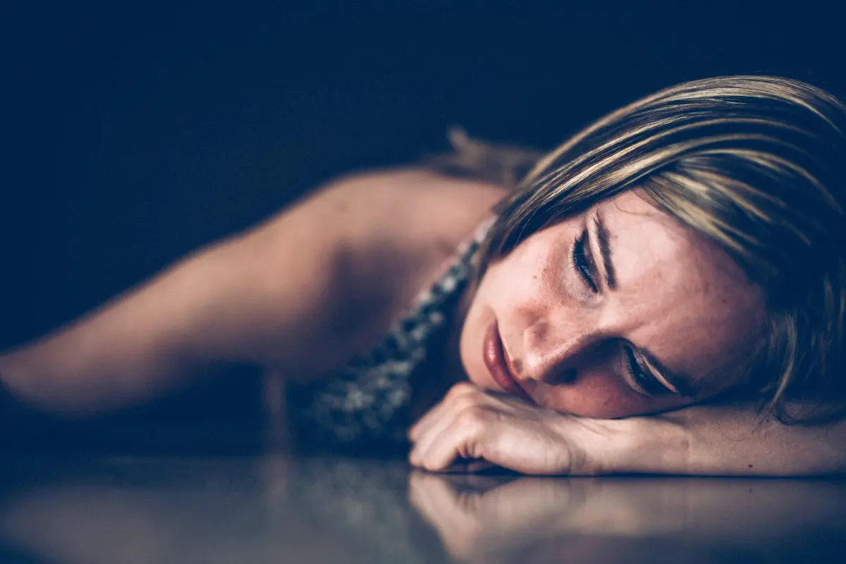 Mulher triste debruçada sobre a mesa